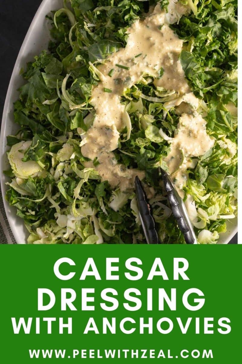 Salad with Caesar dressing and anchovies, served on a platter with metal tongs. Text overlay reads "Caesar Dressing with Anchovies" and website URL at the bottom.