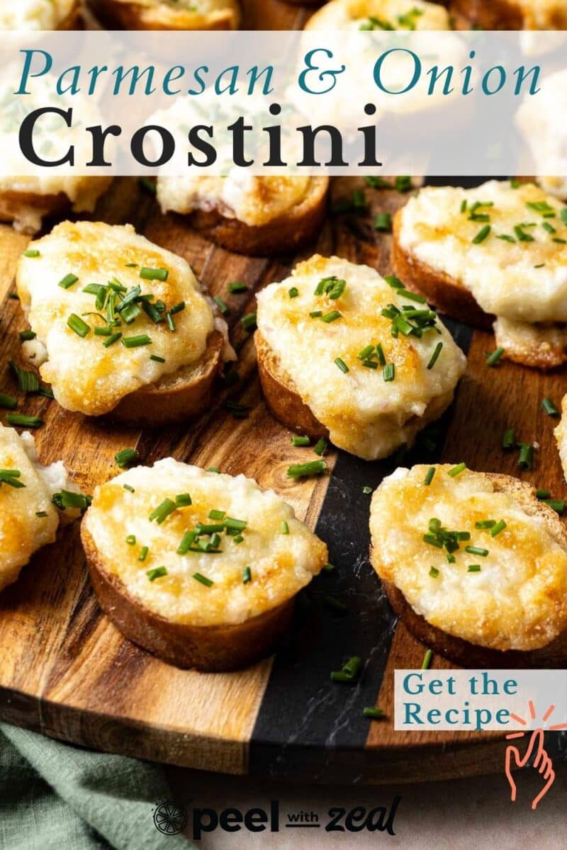 Close-up of parmesan and onion crostini topped with chives on a wooden platter. Text overlay reads "Parmesan & Onion Crostini" and "Get the Recipe" with a logo at the bottom.