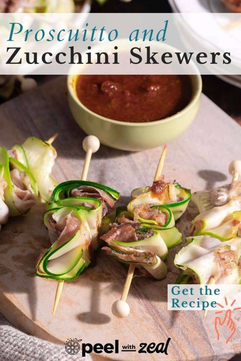 Prosciutto and zucchini skewers on a wooden board with a bowl of dipping sauce in the background. Text reads "Prosciutto and Zucchini Skewers" and "Get the Recipe.