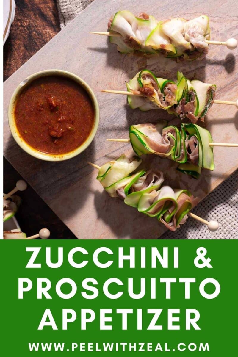 Skewers of zucchini and prosciutto with a side of dipping sauce on a wooden board. Text reads "Zucchini & Prosciutto Appetizer" and "www.peelwithzeal.com.