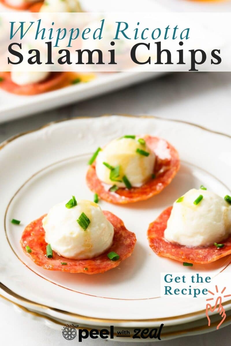 Plate with salami slices topped with whipped ricotta and chives. Text overlay reads, "Whipped Ricotta Salami Chips.