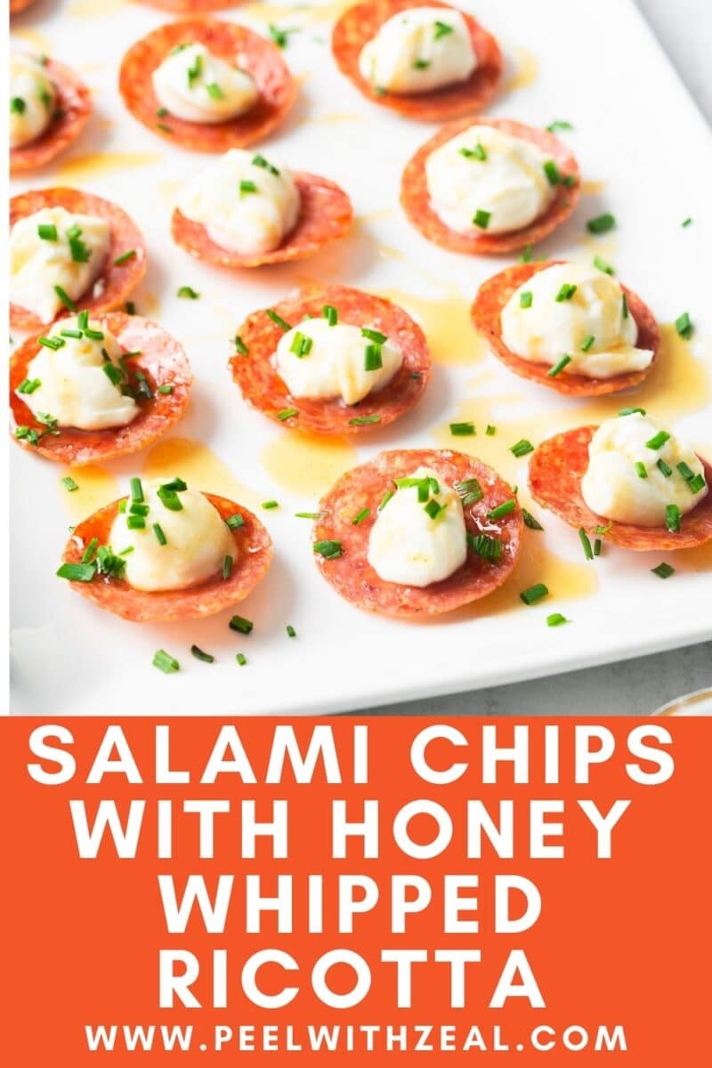 Salami chips topped with honey whipped ricotta and chives on a white plate. The text reads, "Salami Chips with Honey Whipped Ricotta.