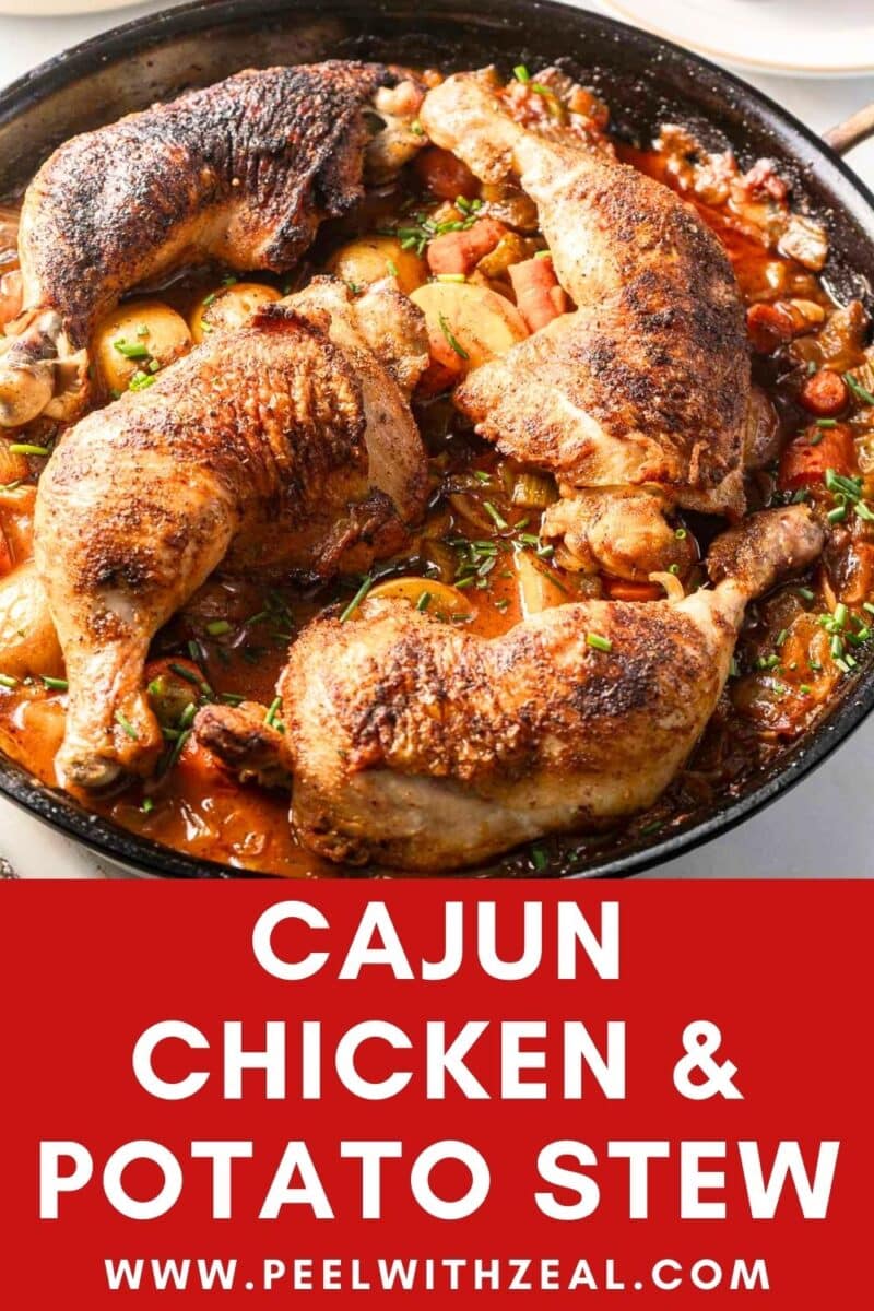 A skillet of Cajun chicken stew, featuring browned chicken legs and a mix of vegetables in a rich sauce.