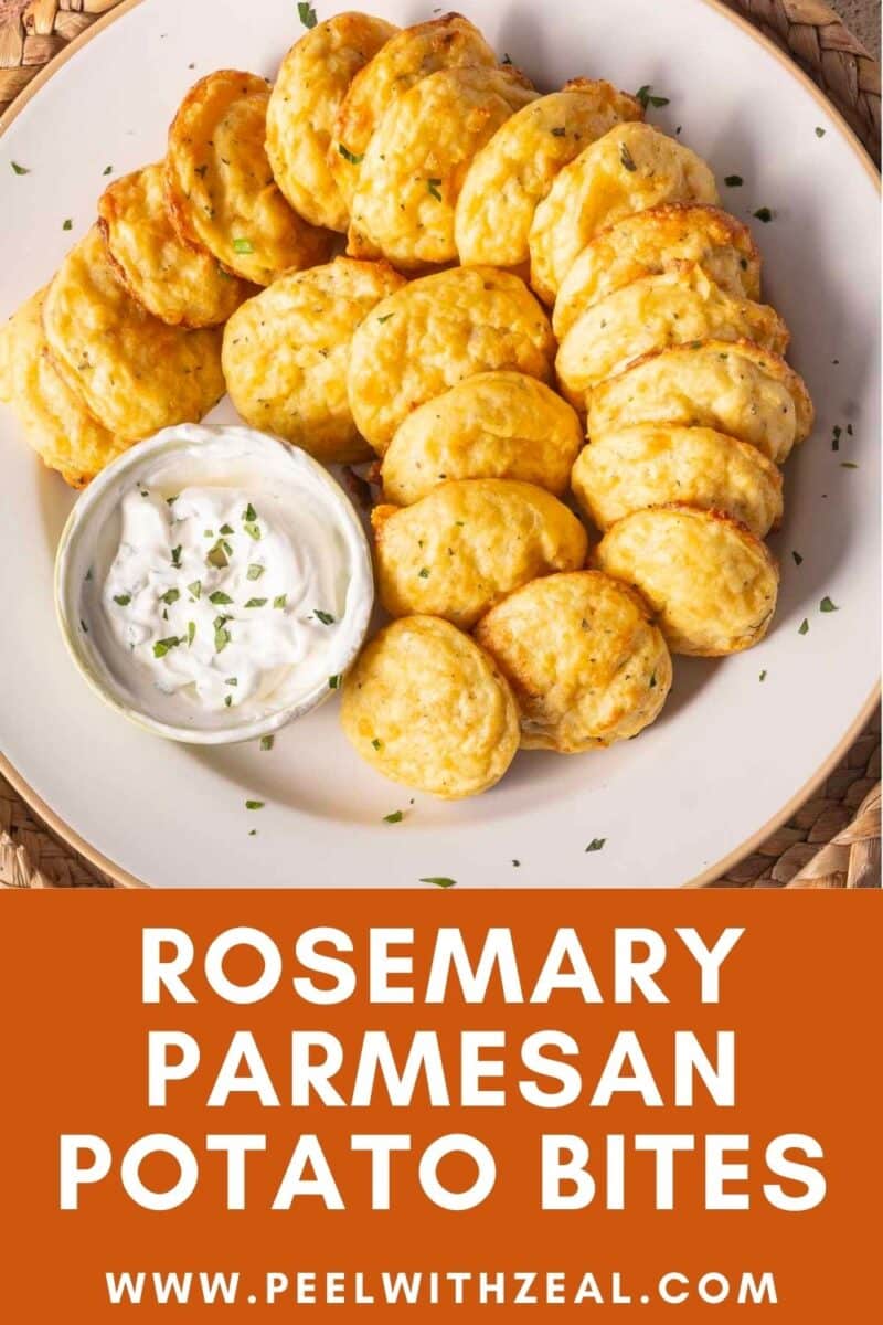 Plate of rosemary parmesan potato bites arranged around a small bowl of dipping sauce, garnished with herbs.