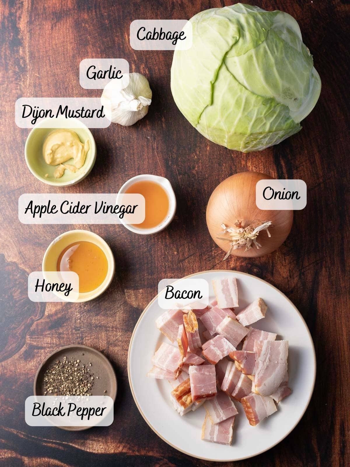 Fried cabbage mingles deliciously with crispy bacon, aromatic garlic, and savory onions. A touch of Dijon mustard and a drizzle of honey blend perfectly with apple cider vinegar, all arranged beautifully on a rustic wooden surface.