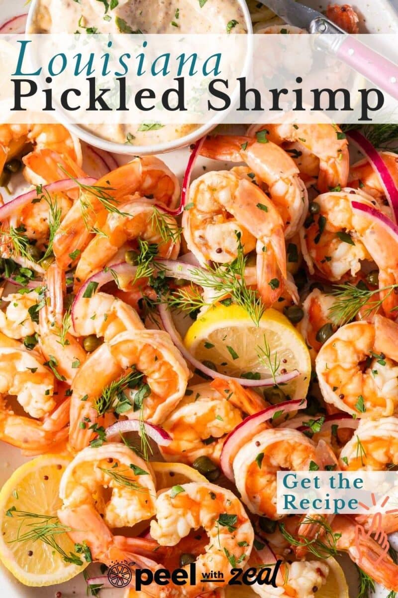 Plate of Louisiana pickled shrimp with dill, lemon slices, and red onions on a white dish.