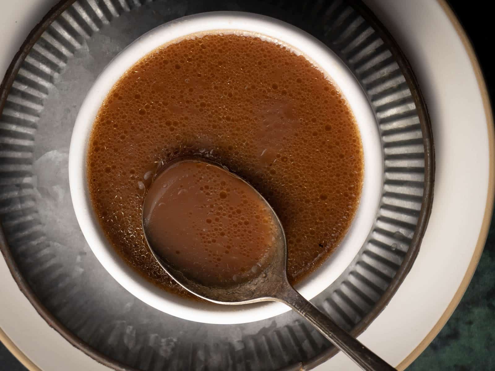 au jus sauce in a bowl with a spoon.