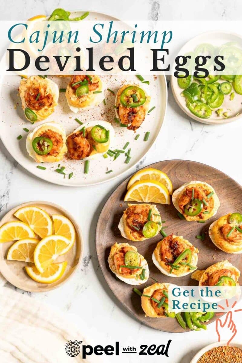 Three plates of deviled eggs topped with shrimp, jalapeños, and chives. Lemon wedges are on the side. Text reads "Cajun Shrimp Deviled Eggs" and "Get the Recipe.