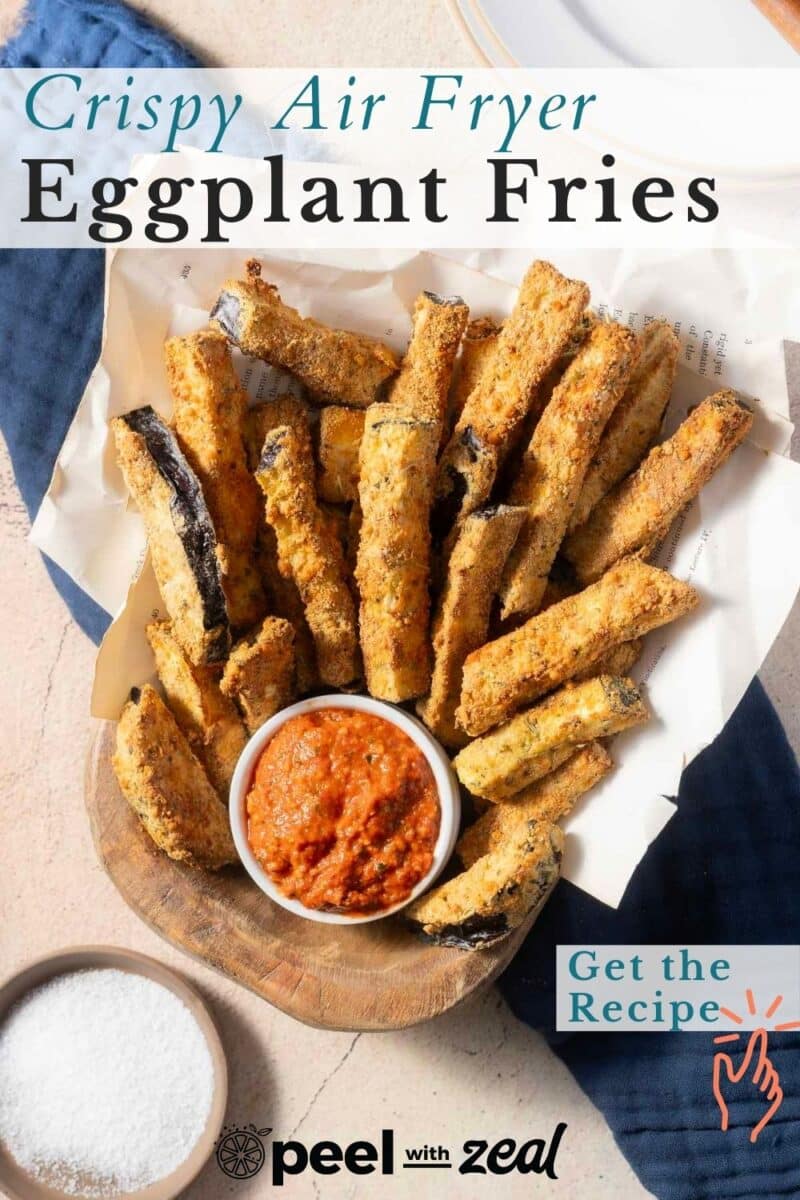 A bowl of crispy air fryer eggplant fries with a side of red dipping sauce, accompanied by a small bowl of salt. A "Get the Recipe" badge is displayed.