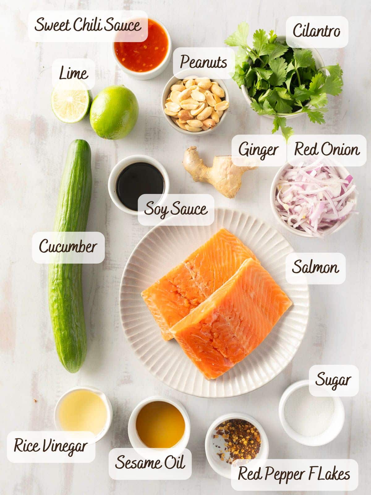 A vibrant array of ingredients awaits on the surface, ready to transform into a delicious Sweet Chili Salmon. Picture sweet chili sauce, lime, peanuts, cilantro mingling with cucumber salad elements like soy sauce and ginger, all poised to accompany savory salmon with a hint of sesame oil and red pepper flakes.