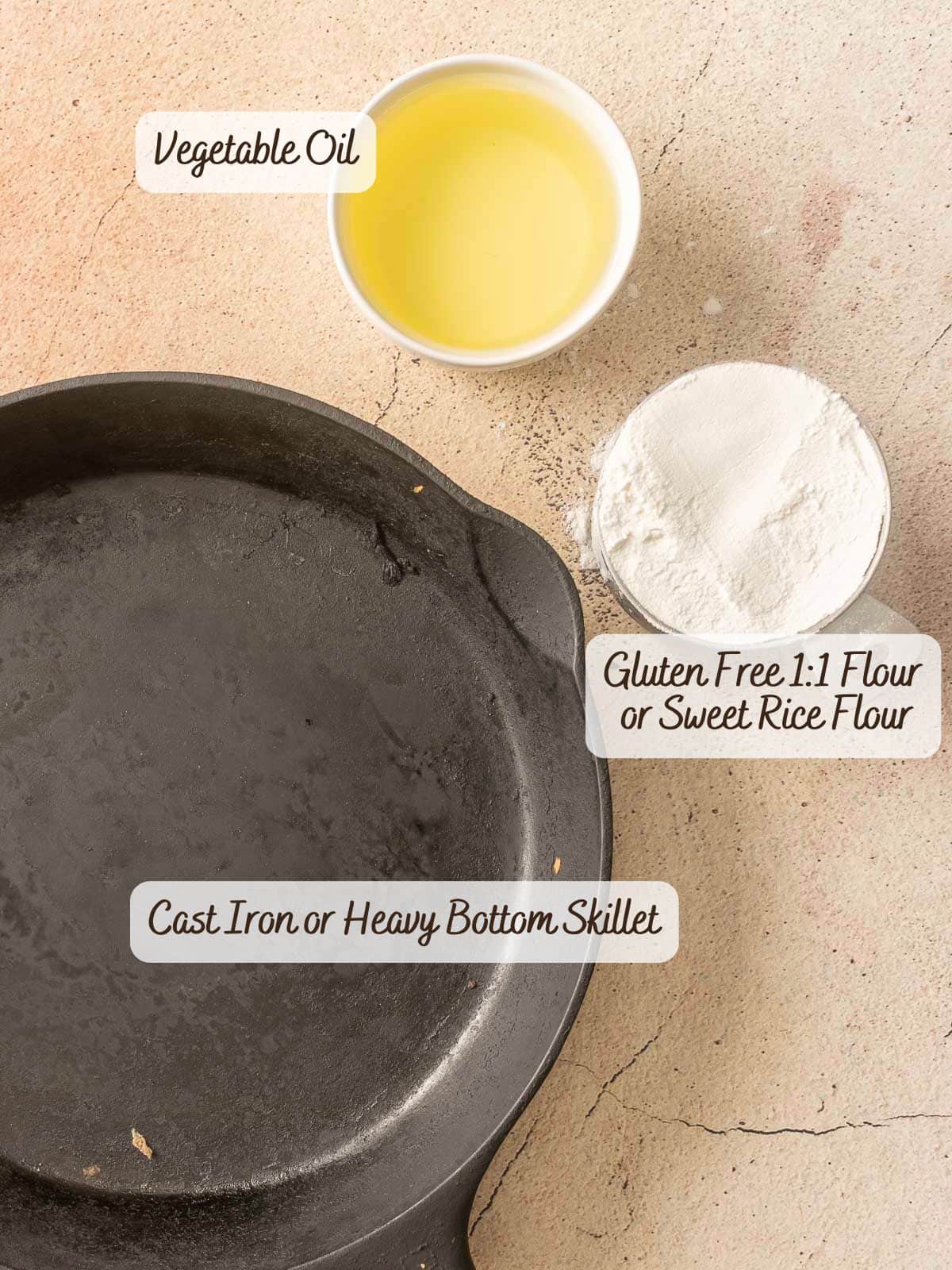 A cast iron skillet, a bowl of vegetable oil, and gluten-free flour sit ready on a light textured surface, perfect for crafting a rich roux to enhance your favorite gumbo recipe.