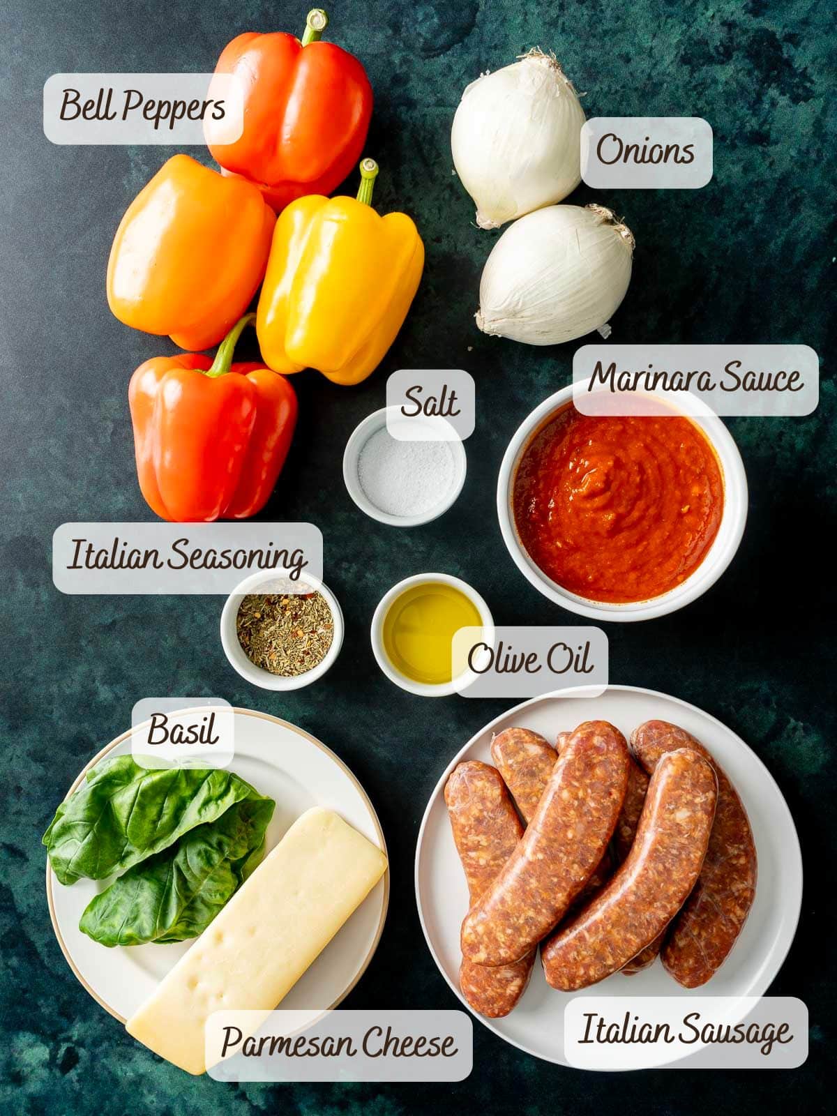 Ingredients displayed on a dark surface include bell peppers, onions, baked Italian sausage, marinara sauce, olive oil, salt, Italian seasoning, basil, and Parmesan cheese.