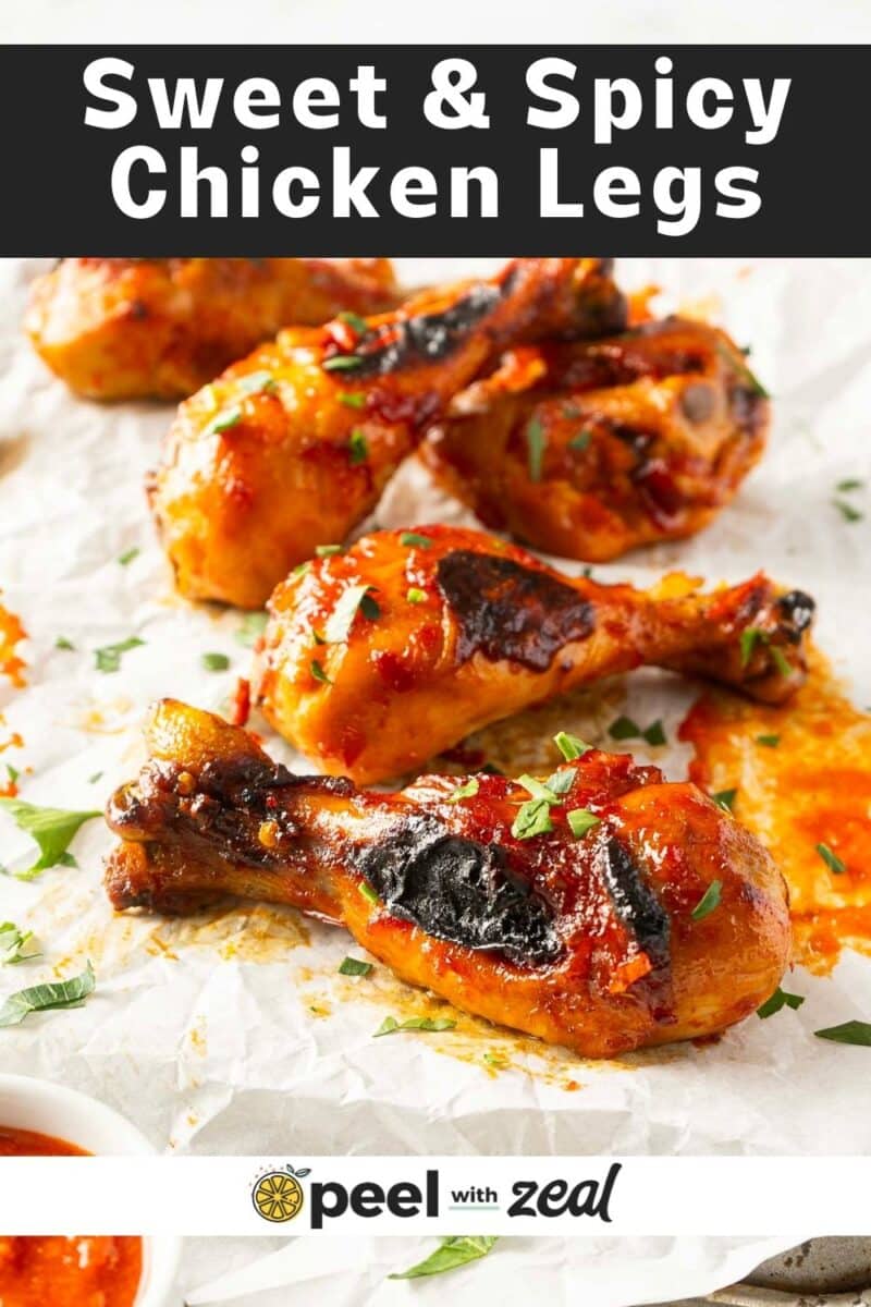 Five glazed chicken legs with seasoning are arranged on parchment paper, garnished with herbs. Text above reads "Sweet & Spicy Chicken Legs.