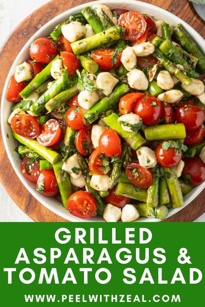 A bowl of delicious grilled asparagus and tomato salad, featuring cherry tomatoes and mozzarella, elegantly garnished with fresh herbs.