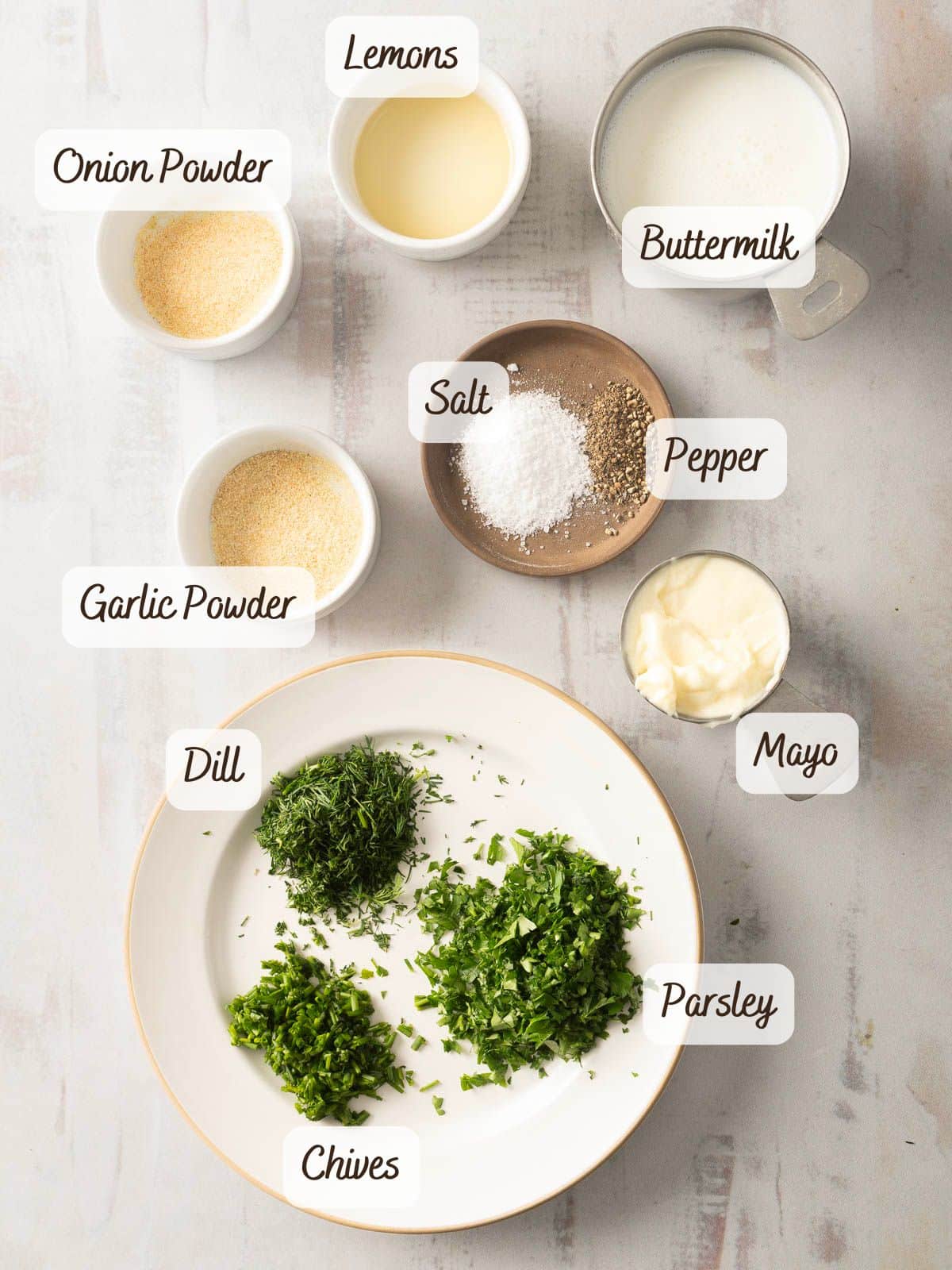 Ingredients for buttermilk ranch dressing on a light surface.
