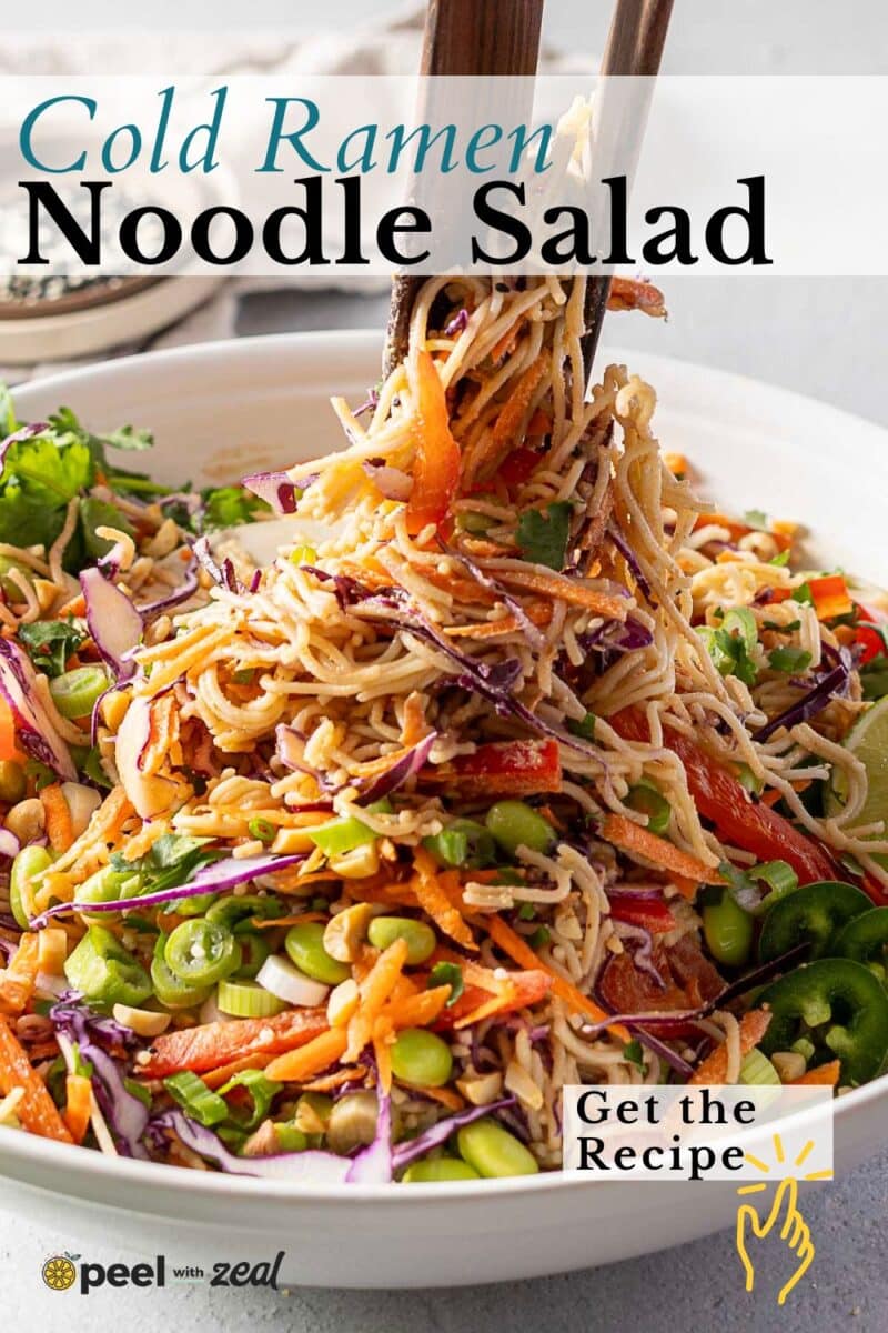 Chopsticks gracefully lift a refreshing cold ramen noodle salad with vibrant vegetables from a white bowl.