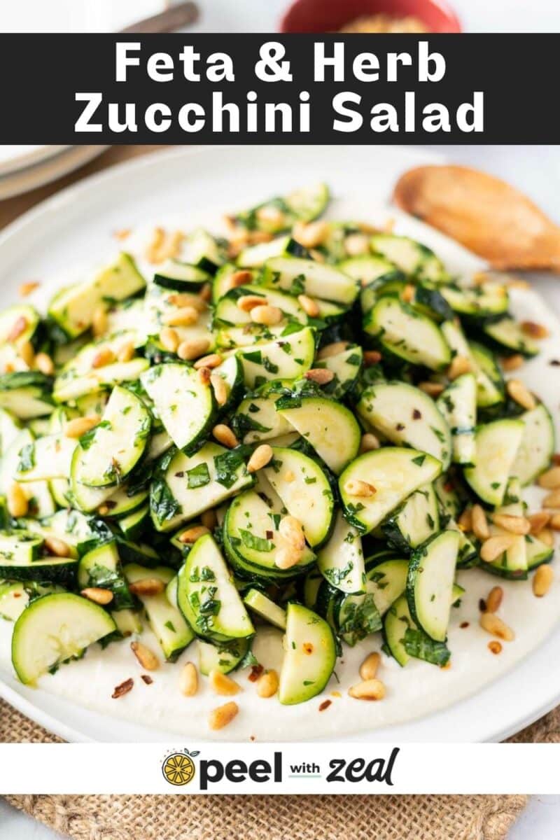 A refreshing dish featuring zucchini salad, enhanced with creamy feta, fresh herbs, and crunchy pine nuts, all topped with a tangy dressing.
