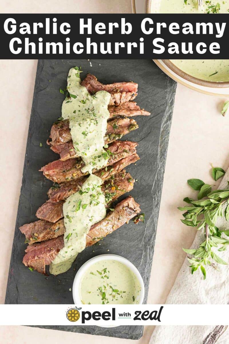 Sliced steak with Creamy Chimichurri Sauce on a slate board, garnished with fresh herbs. A bowl of the rich sauce sits beside it. Text: "Garlic Herb Creamy Chimichurri Sauce".
