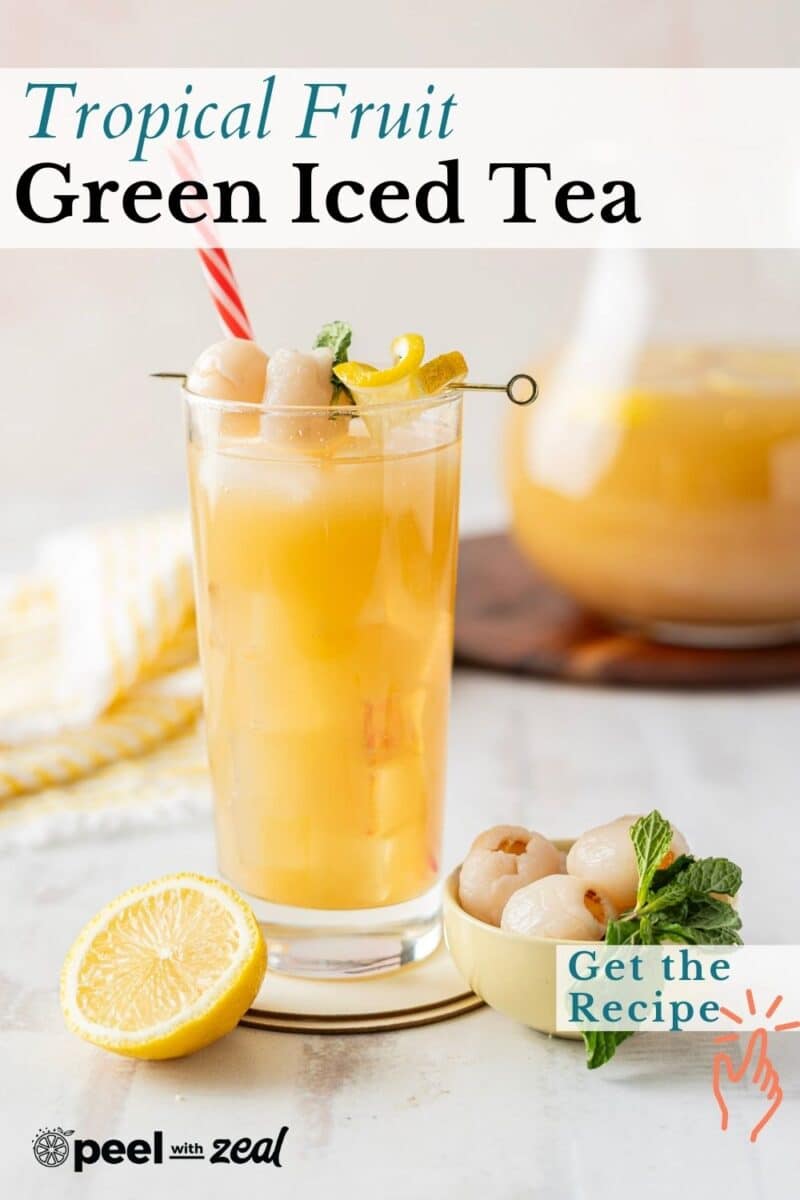 A tall glass of lychee-infused tropical fruit green iced tea, adorned with lemon and mint, all sipped through a vibrant red straw.