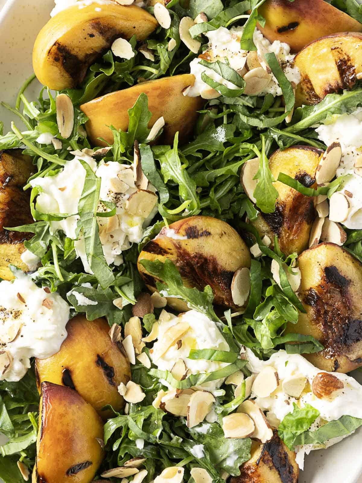 grilled peach slices, arugula, creamy burrata cheese, and crunchy sliced almonds.