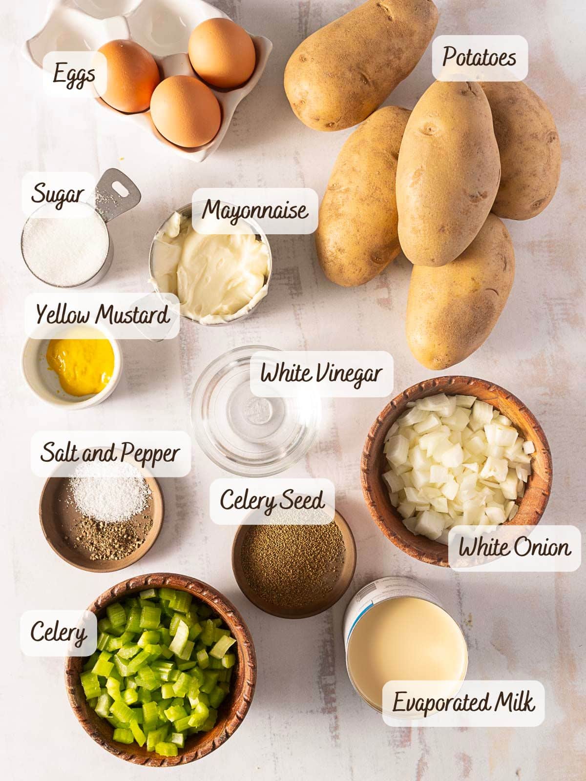 Ingredients for an old-fashioned potato salad include eggs, potatoes, sugar, mayonnaise, yellow mustard, white vinegar, salt, pepper, celery seed, white onion, celery, and evaporated milk.