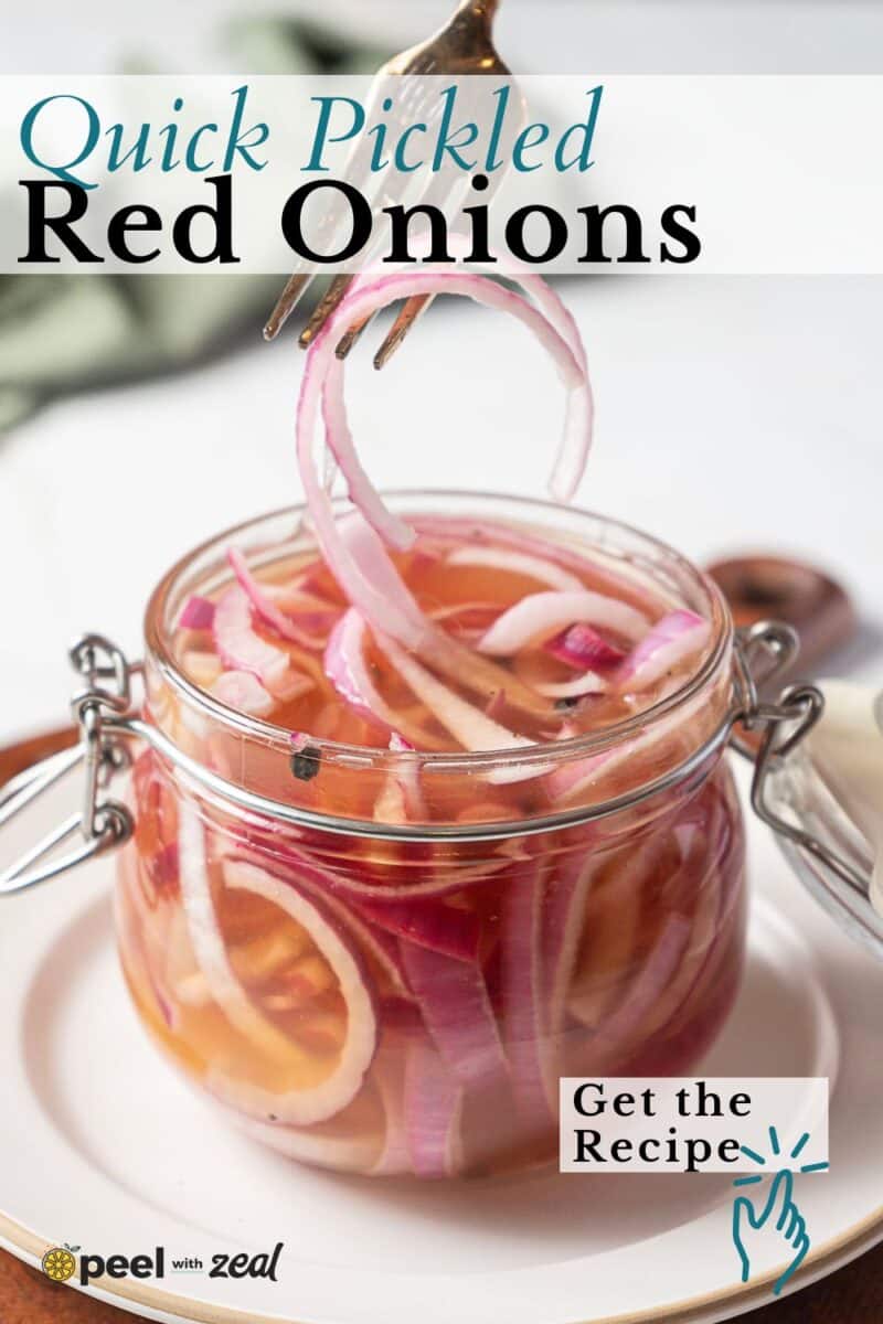 A glass jar filled with quick pickled red onions in tangy pickling liquid, with a fork lifting some onions out of the jar.