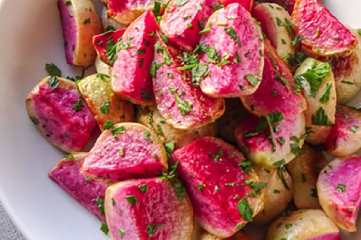 Diced red and white radishes garnished with chopped parsley in a white bowl make for a vibrant, gluten-free addition to your Easter recipes collection.