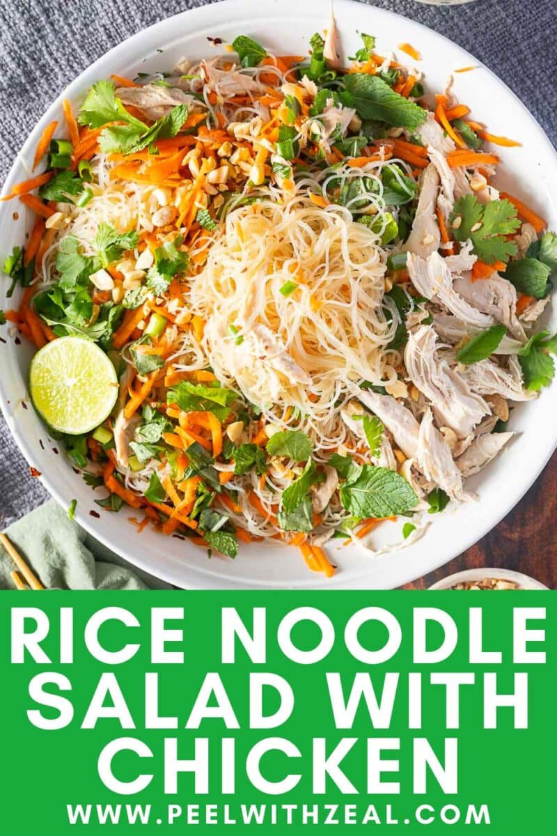 A delightful bowl of rice noodle salad with chicken, carrots, fresh herbs, nuts, and a splash of lime.