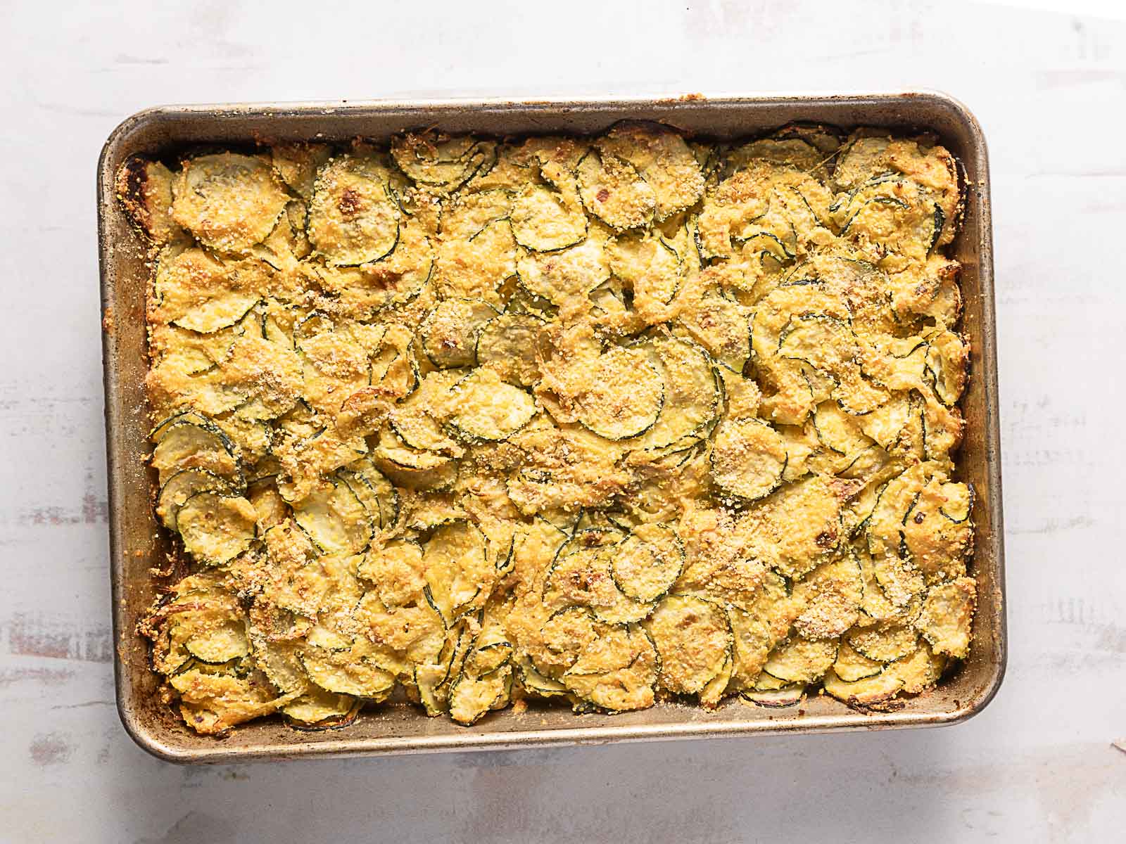 A rectangular baking dish filled with a baked zucchini casserole topped with a golden brown crust.