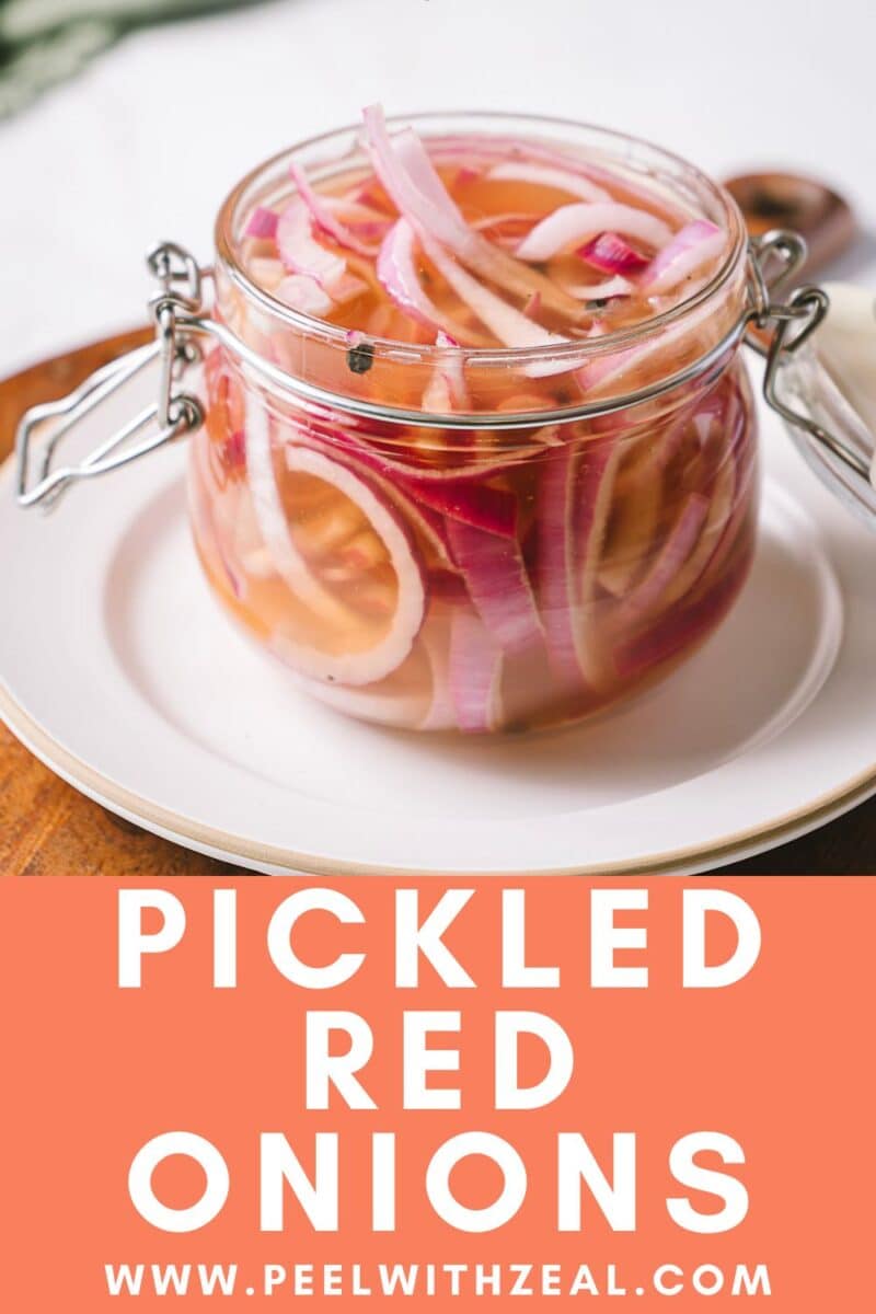 A glass jar filled with quick pickled red onions in pickling liquid sits on a white plate.