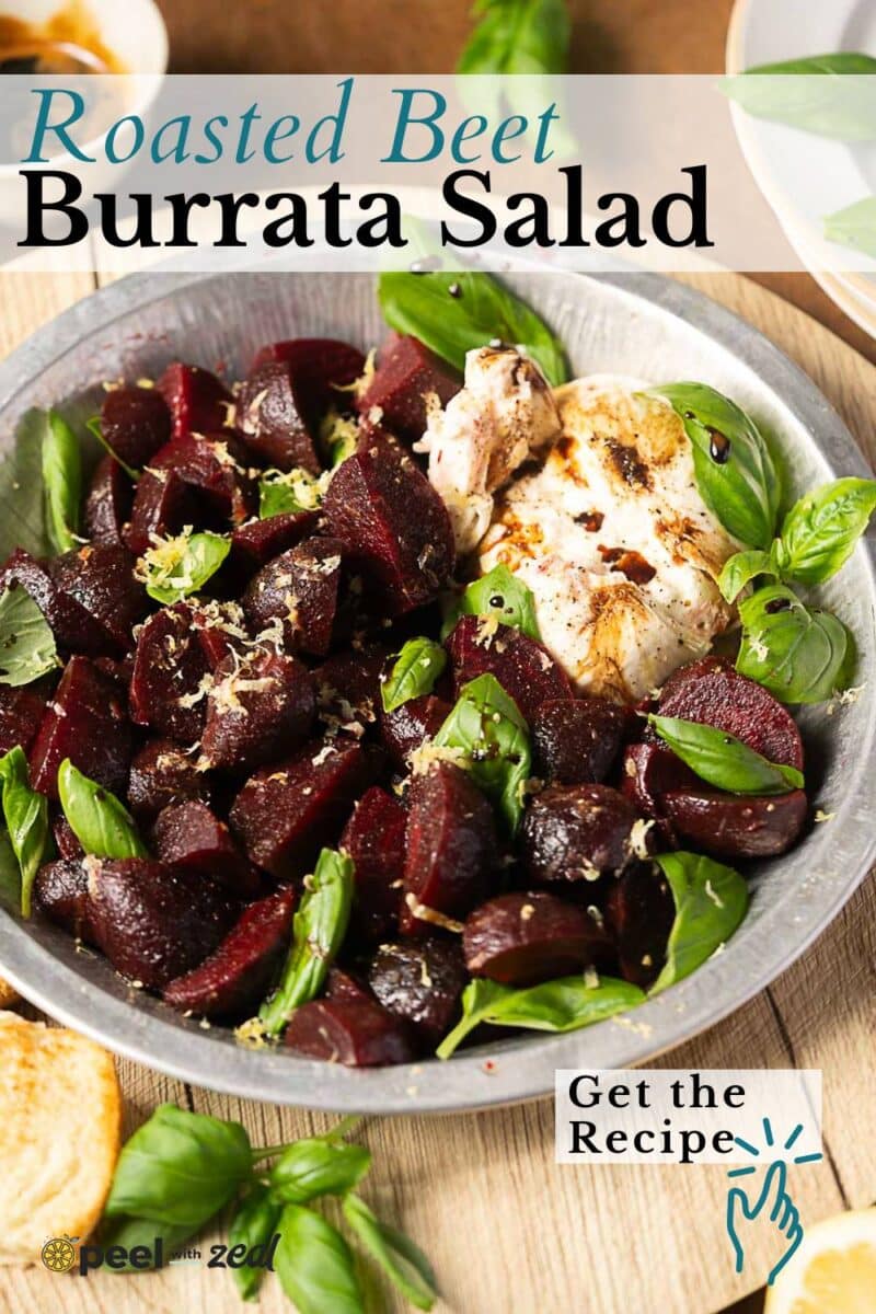 A delicious beet and burrata salad garnished with fresh basil leaves, served with lemon zest and toasted bread on the side.