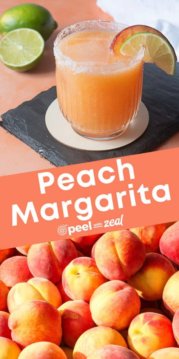 A peach margarita in a glass with a salted rim and peach slice garnish sits on a slate coaster, with fresh limes and peaches in the background.