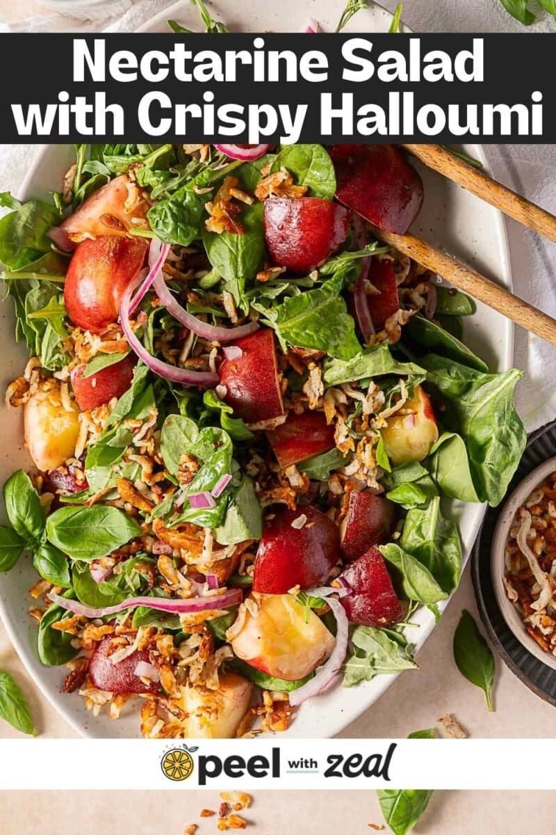 A vibrant nectarine salad featuring crispy halloumi, arugula, red onion, fresh basil, and toasted rice fills the bowl, served alongside two wooden utensils for a perfect summer dish.