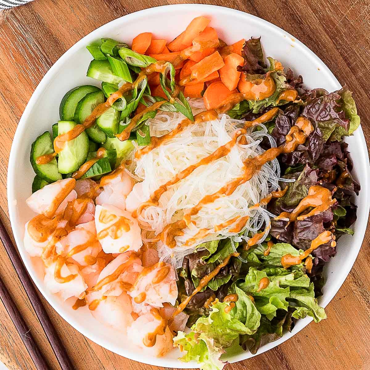 shrimp spring roll bowl on top of a wooden surface