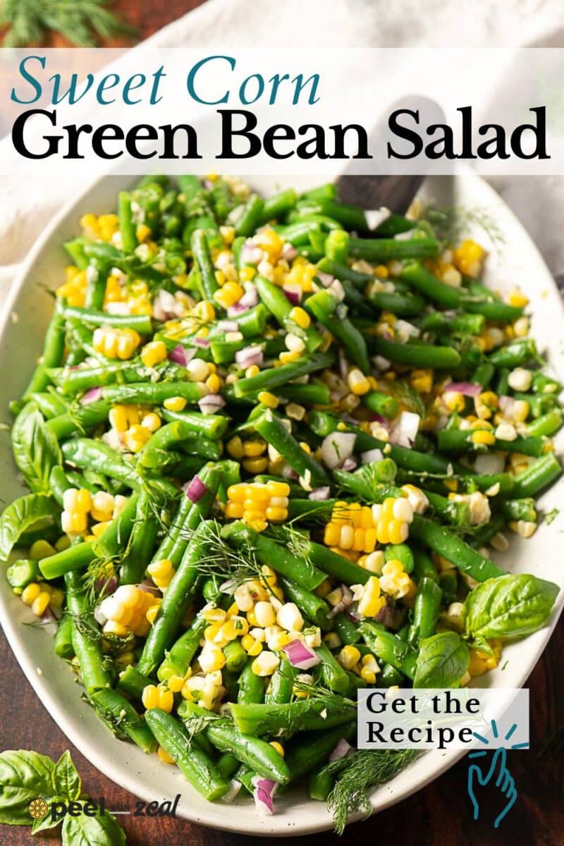A vibrant green bean corn salad platter with red onion and fresh herbs, garnished with basil and dill.