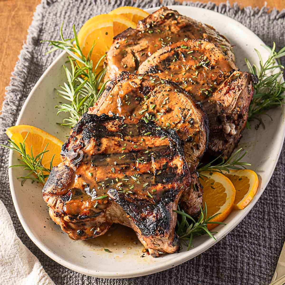 marinated grilled bone-in pork chops on a white plate
