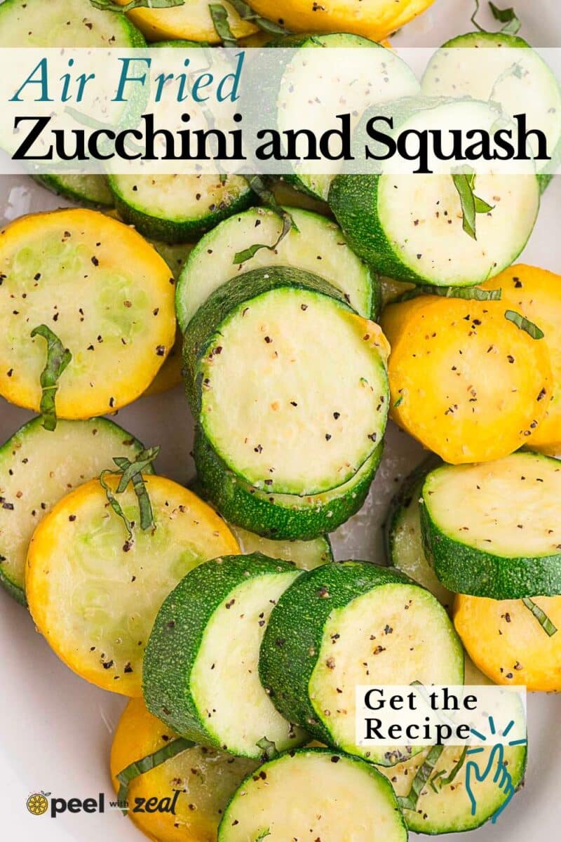 Air fryer zucchini and squash slices, seasoned with pepper and garnished with fresh herbs, arranged beautifully on a white plate.