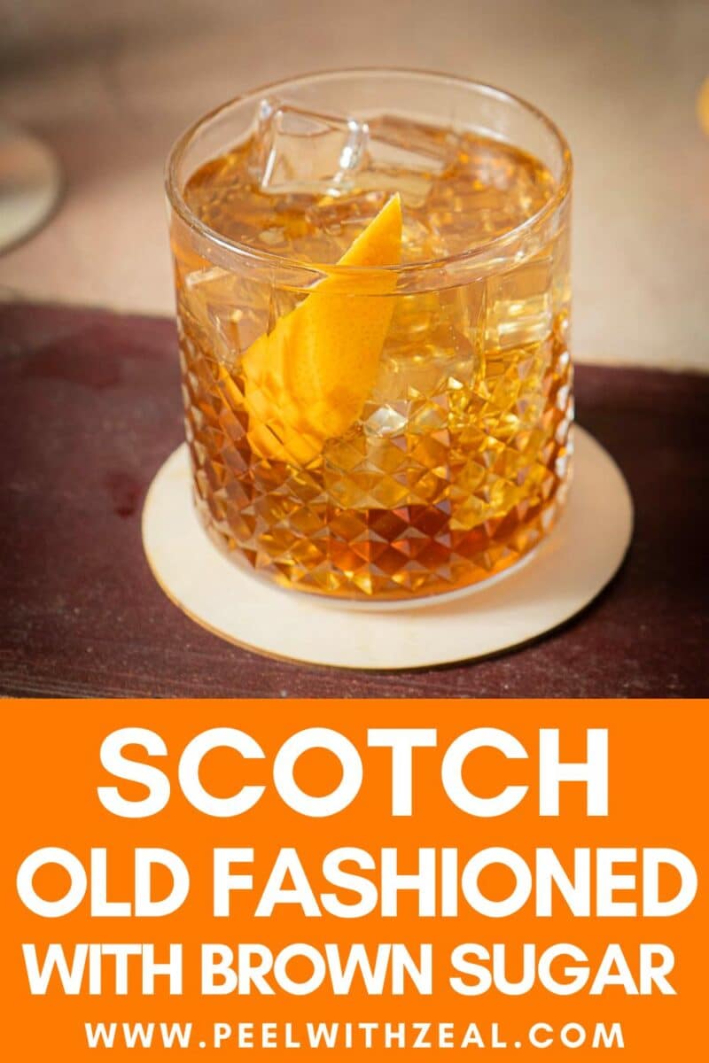 A glass of scotch old fashioned with ice and an orange peel garnish rests on a coaster. Text at the bottom reads, "Scotch Old Fashioned with Brown Sugar www.peelwithzeal.com.