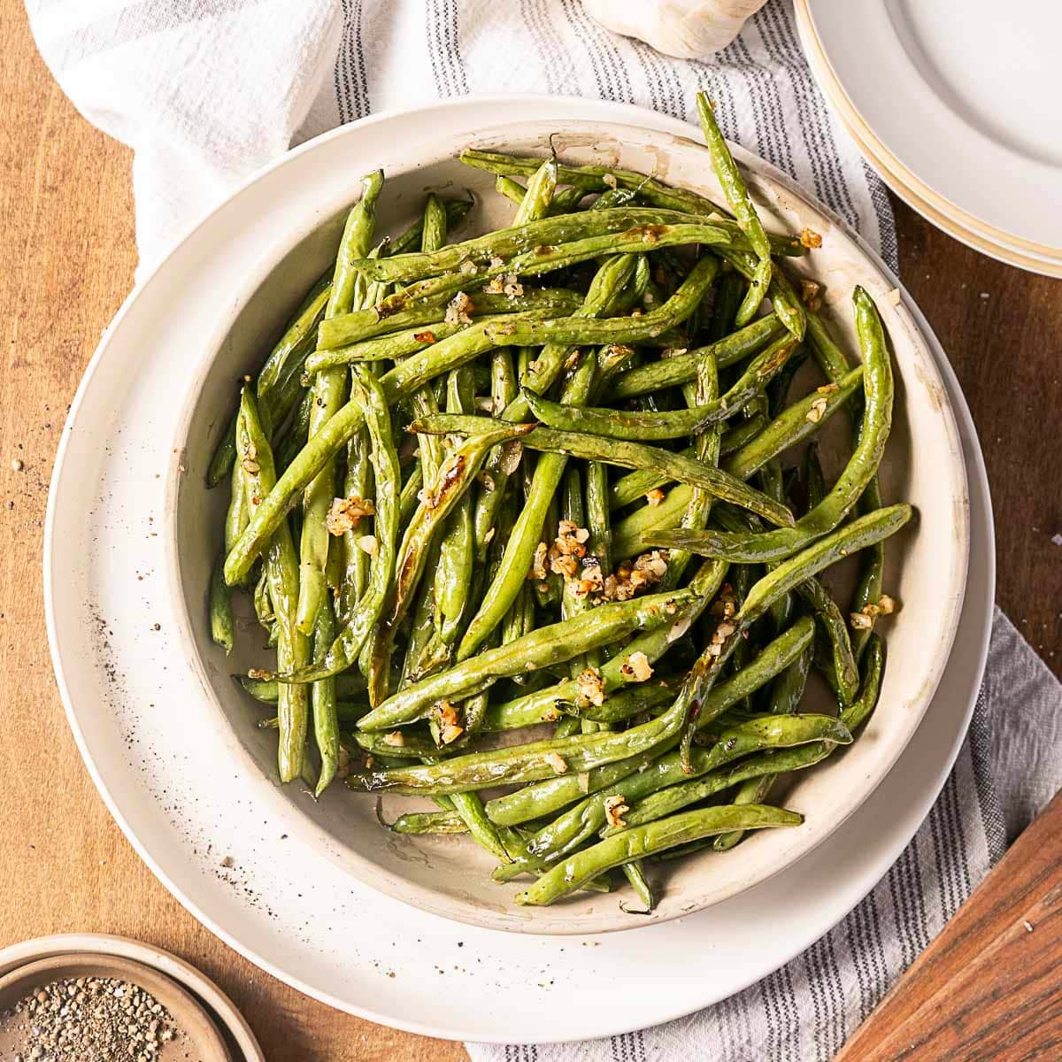 garlic roasted green beans on a white plate