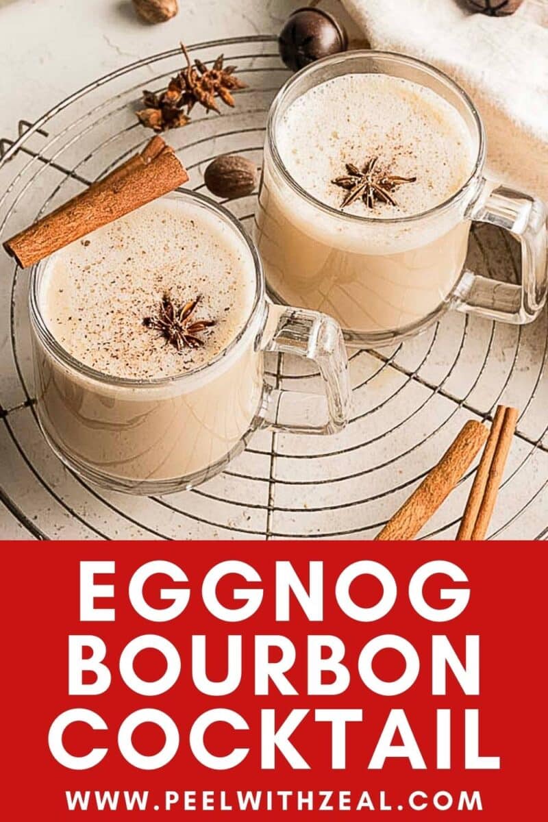 Two glass mugs of eggnog cocktail garnished with cinnamon sticks and star anise, placed on a cooling rack with extra spices beside them for a festive holiday presentation.