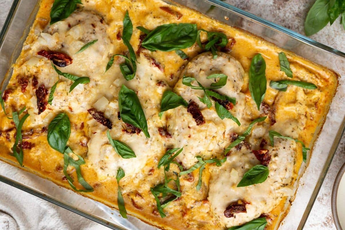 Baked chicken breasts in a creamy sauce with sun-dried tomatoes, topped with melted cheese and fresh basil leaves—a perfect choice for quick dinners or easy family dinners.