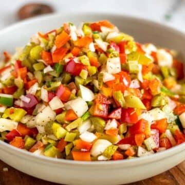 A bowl filled with finely chopped mixed vegetables including red and green peppers, onions, and celery—perfect for adding freshness to your favorite Game Day Dips.