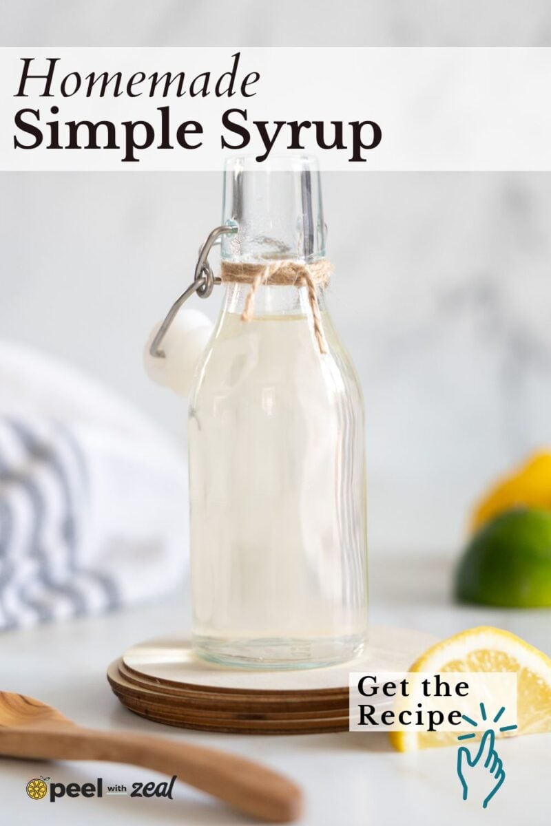 A glass bottle of homemade simple syrup on a coaster, with a lemon wedge and a striped towel in the background. Text reads "Homemade Simple Syrup" and "Get the Recipe.