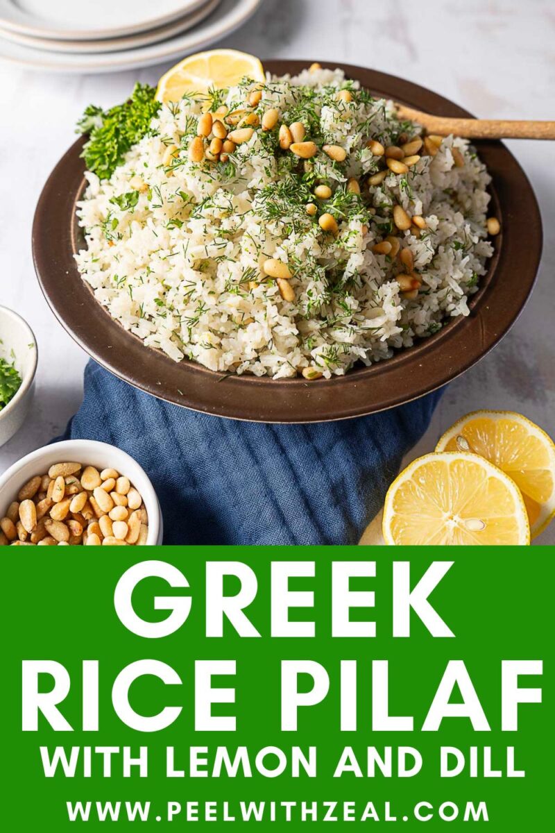 A bowl of Greek rice pilaf garnished with pine nuts, dill, and lemon slices, set on a blue napkin with lemon halves and a small bowl of pine nuts nearby.