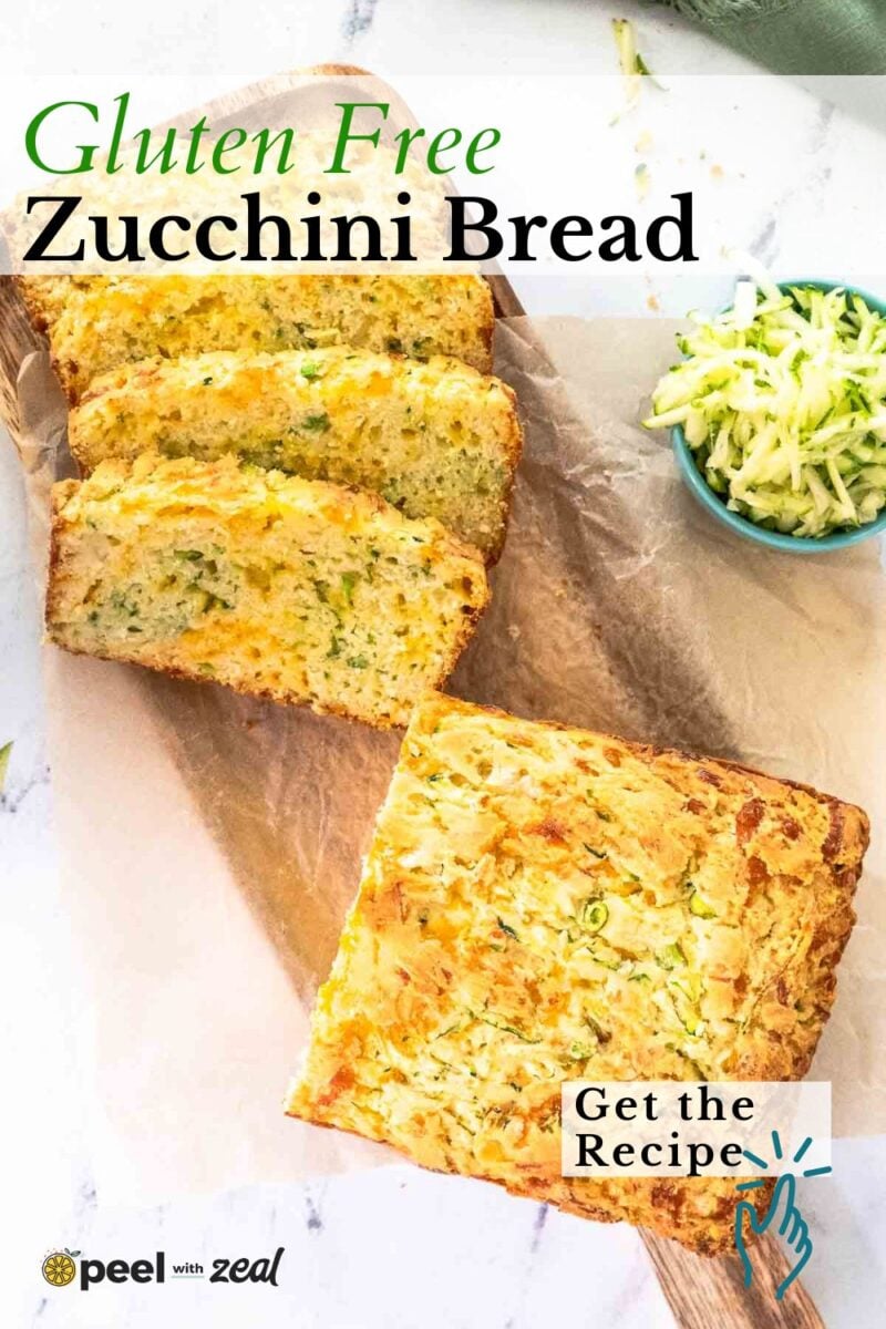 Sliced loaf of gluten free zucchini bread on parchment paper with a small bowl of shredded zucchini beside it. Text reads "Gluten Free Zucchini Bread. Get the Recipe.