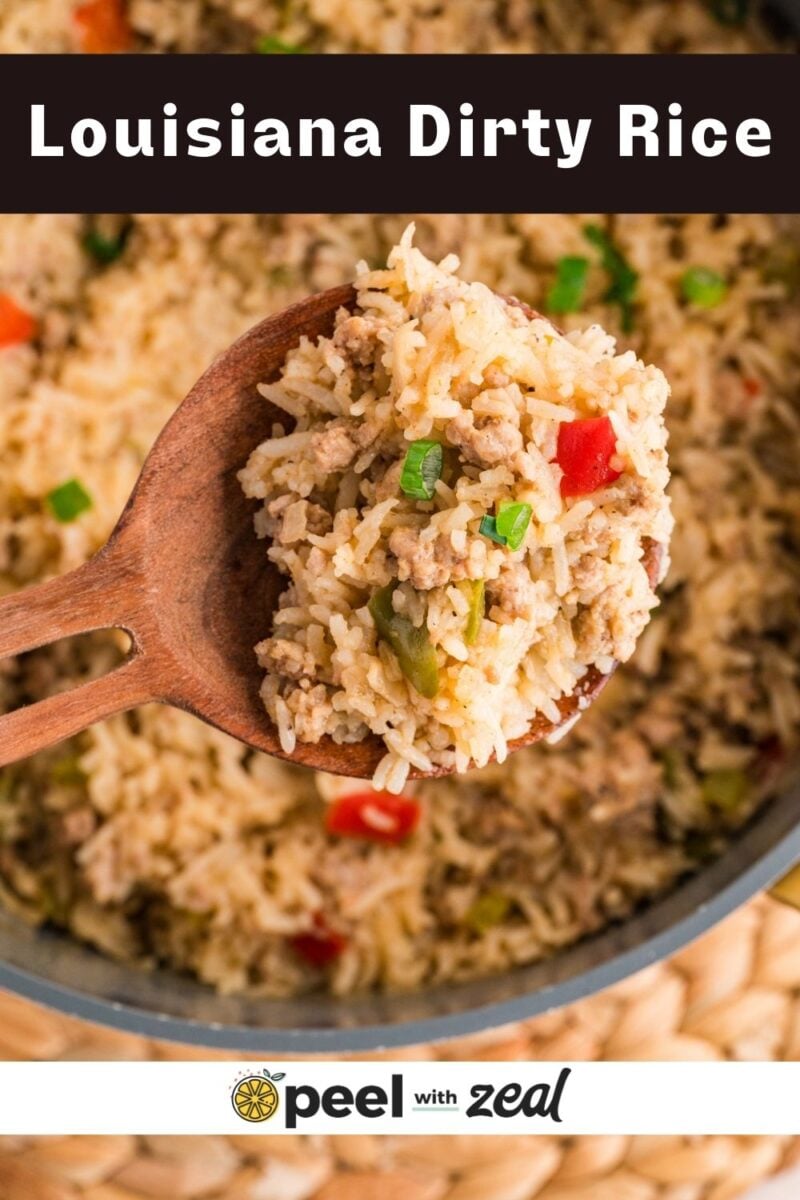 A wooden spoon holds a serving of Louisiana dirty rice with ground meat, rice, and chopped vegetables over a pot of the same dish.