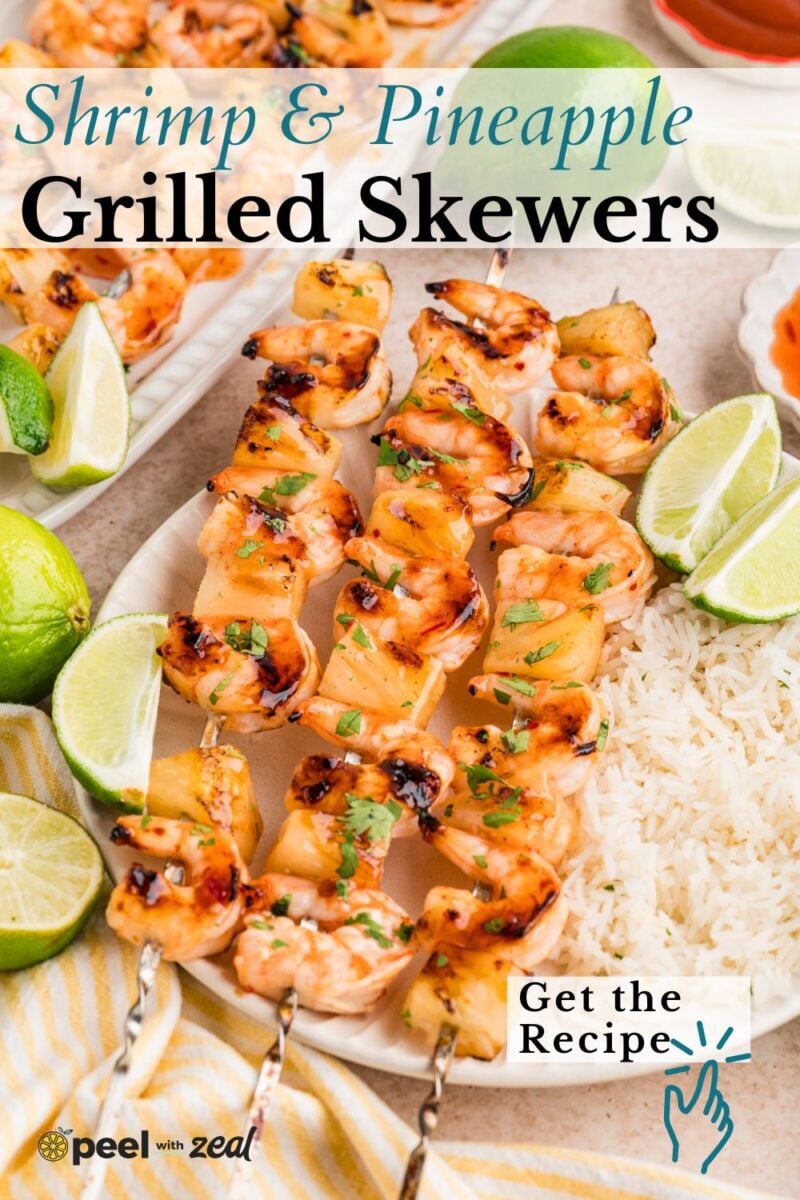 Skewers with grilled shrimp and pineapple are arranged on a plate, served with rice, lime wedges, and a small bowl of sauce. Text reads, "Shrimp & Pineapple Grilled Skewers.