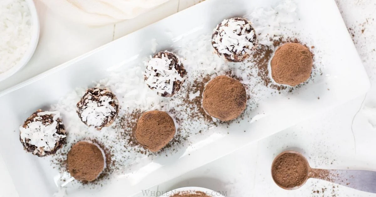A rectangular white plate with eight round chocolate truffles, some topped with shredded coconut and others dusted with cocoa powder, arranged in two rows.