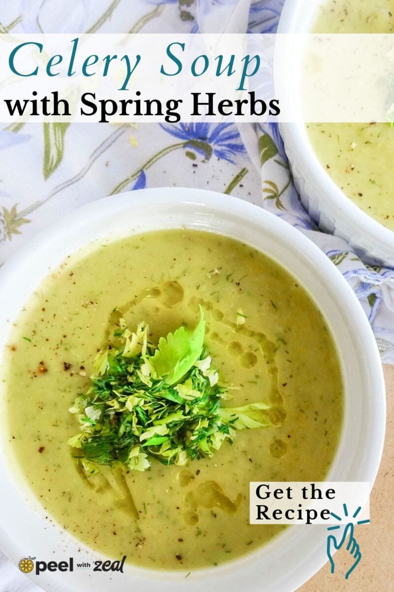 Two bowls of creamy celery soup garnished with chopped herbs and a celery leaf, placed on a floral napkin.
