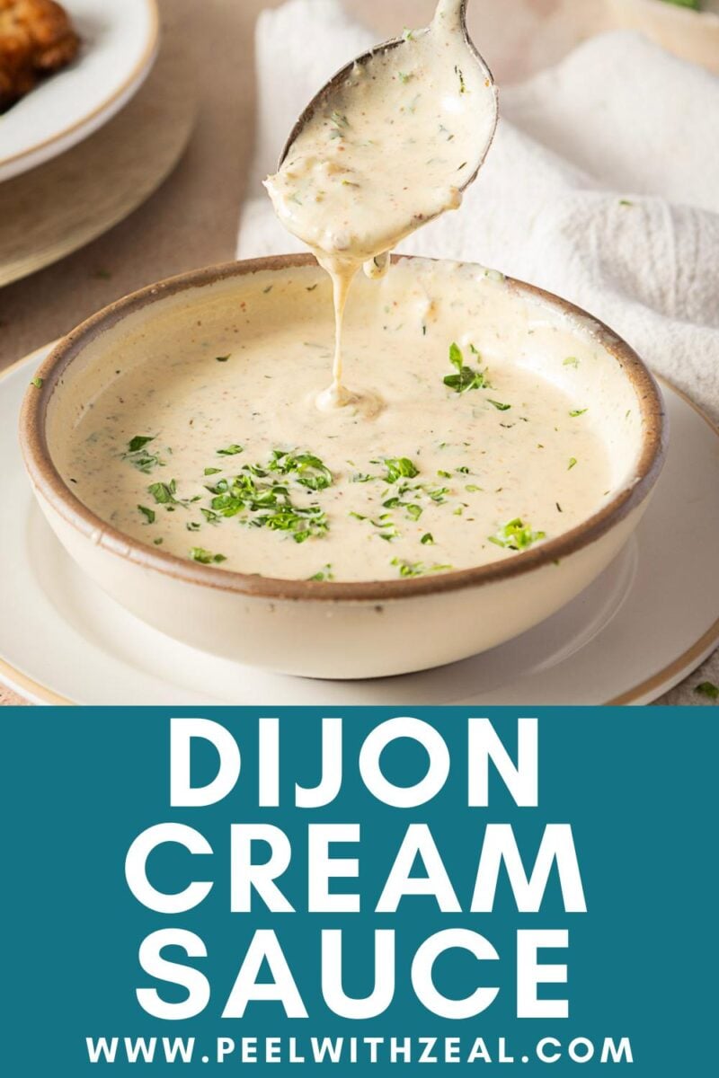 A spoon drizzles luscious dijon cream sauce over a bowl, garnished with chopped herbs